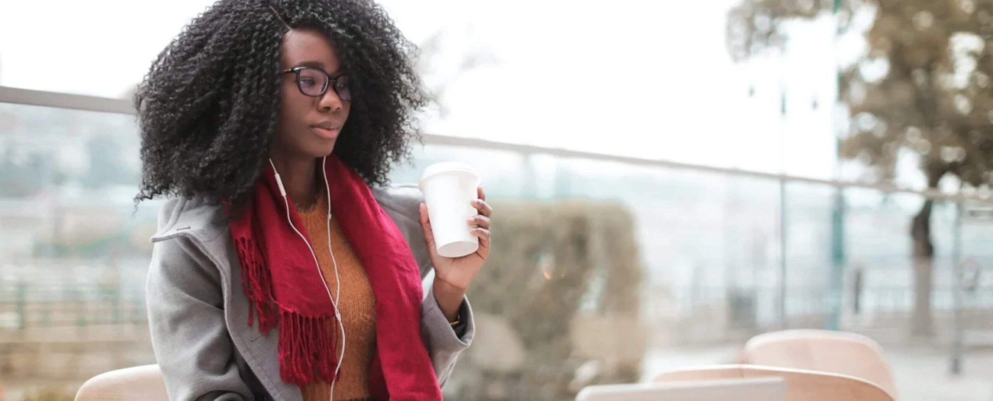 Student learning online with earphones and coffee